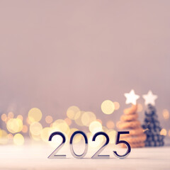 Metal numbers 2025 on a white table with Christmas trees and bokeh lights. Happy New Year 2025 is...