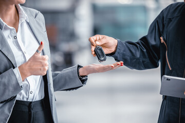 Closeup male hand giving a car key for vehicle loan credit financial, lease or rental concept