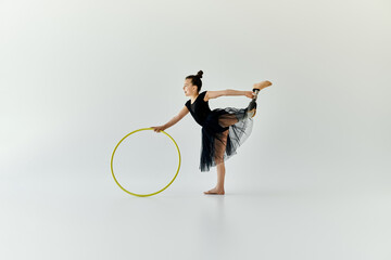 A young girl with a prosthetic leg practices gymnastics with a hula hoop.