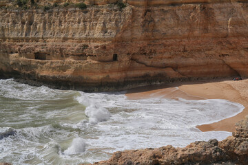 Fliessende Wellen an der Küste vor Sandstein in der Algarve