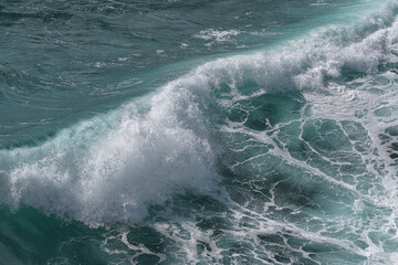 Wellenformationen mit Gischt an der Küste mit Schaumkronen