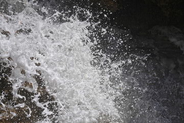 Wild aufschäumende Wellen zeigen ihr Spiel mit zahlreichen Wassertropfen