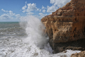 Grosse Wellen schlagen an der Sandsteinküste in der Algarve auf bei hohem Seegang 