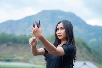 Woman taking a selfie in a mountainous outdoor setting