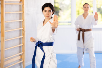 Women in kimonos are focusing on their hand punch training, refining their striking techniques.