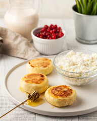 Curd cottage cheese pancakes with honey on ceramic plate