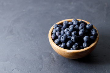 Ripe organic blueberries on black stone table background. Selective focus.