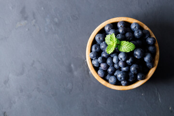 Ripe organic blueberries on black stone table background. Selective focus.