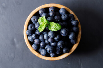Ripe organic blueberries on black stone table background. Selective focus.