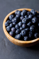 Ripe organic blueberries on black stone table background. Selective focus.