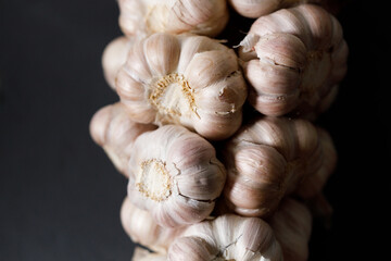 Ripe organic garlic clove and bulb on black stone background.  Close-up. Selective focus.
