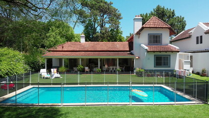 Exterior of suburban home with pool and lawn