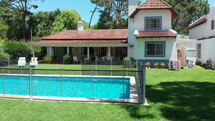 House exterior with swimming pool and lawn