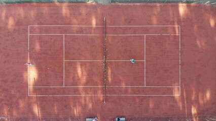 Tennis court seen from above in vertical shot with two players playing a match © Marco