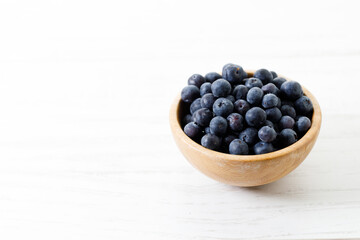 Ripe organic blueberries on white wooden table background. Selective focus.