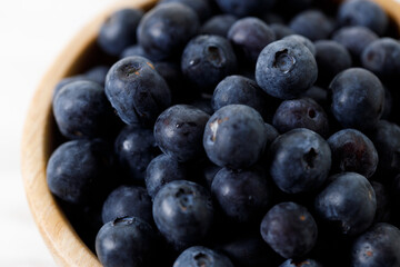 Ripe organic blueberries on white wooden table background. Selective focus.
