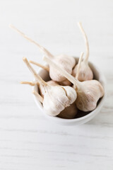 Ripe organic garlic clove and bulb on white wooden background.  Close-up. Selective focus.