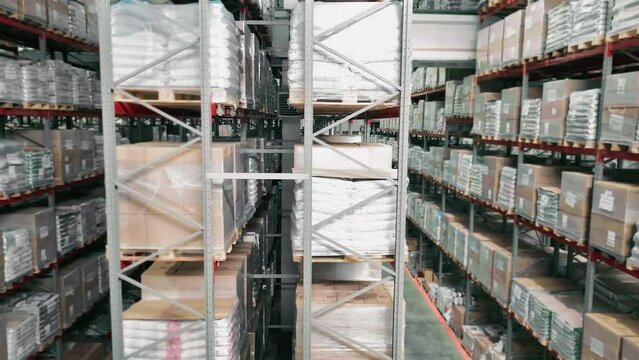 Warehouse aisle with stacked pallets and boxes in storage racks