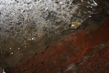 The floor is wet due to water spillage, making it very slippery and potentially causing people to slip.