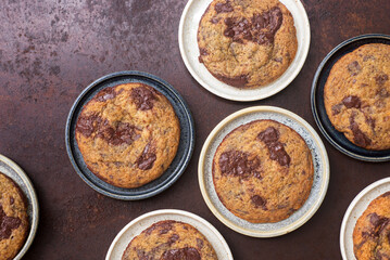 Homemade chocolate chip cookies in ceramic plates on rustic background.