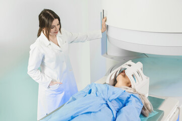 Woman doctor and patient in the MRI room. female assistant preparing adult female patient for MRI scan	