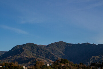 Mountains and clouds. Green mountains in the countryside. Blue sky in mountainous area. Summer holiday in nature.