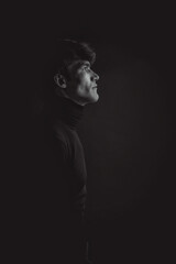 Dramatic portraits series with a young man on dark background