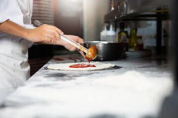 experienced chef - process of making pizza. Professional chef prepares the dough with flour to make pizza or pasta Italian food