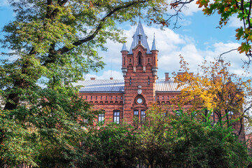 Low angle of traditional building of Municipal Headquarters of the State Fire Service surrounded by trees, Krakow, Poland