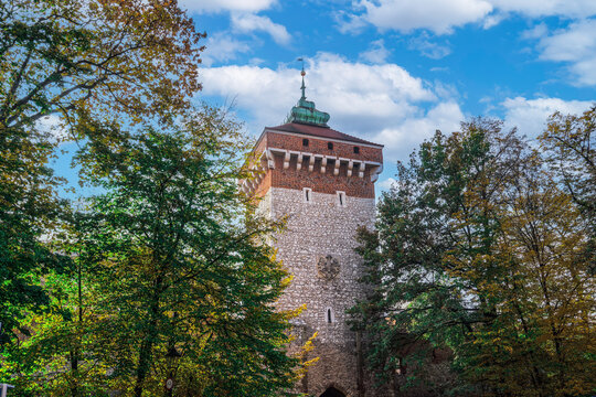 Low angle view of 14th century Gothic tower, Saint Florian Gate (Brama Florianska), against a blue sky with clouds, UNESCO World Heritage Site, Karakow, Poland