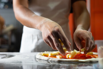 experienced chef - process of making pizza. Professional chef prepares the dough with flour to make pizza or pasta Italian food