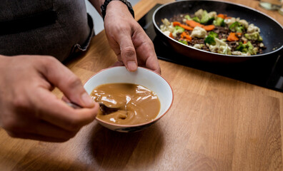 Chef at the kitchen preparing japanese buckwheat pasta with lentils