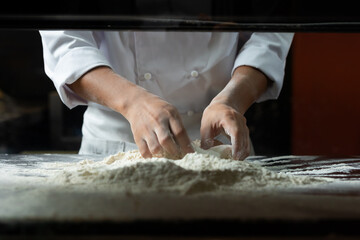 experienced chef - Professional chef prepares the dough with flour to make pizza or pasta Italian food