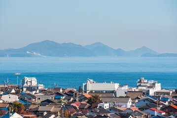 Coastal city roof tops, a calm blue sea and islands on the horizon, Tomonoura, Honshu