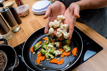 Chef at the kitchen preparing japanese buckwheat pasta with lentils