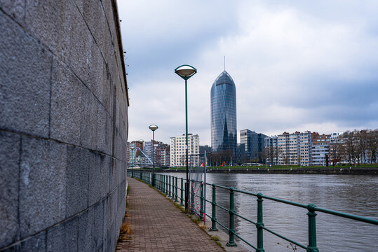 Path along the River Maas, looking along the walkway to La Tour des Finances de Leige (Tour Paradis), Liege, Belgium