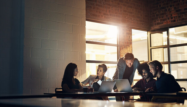 Collaboration, group and night in boardroom, laptop and brainstorming in workspace and teamwork. Workplace, men and women in office, planning and talking for project, creative and auditor in business