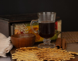 Delicious crunchy cinnamon biscuits with coffe. Dark background