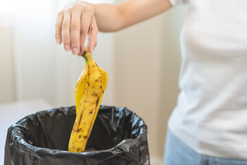 Compost from leftover food asian young housekeeper woman hand putting peel organic banana rotten...