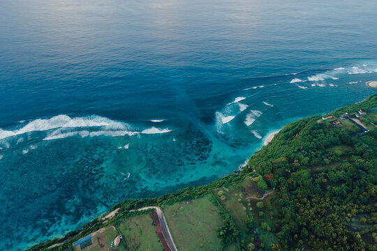 Drone view of coastline with ocean waves and current canal in Bali. Green bowl beach