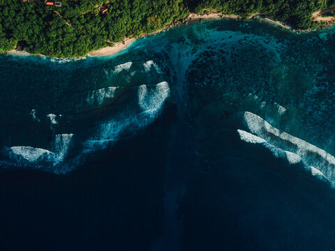 Aerial view of coastline with ocean waves and current canal in Bali. Green bowl beach