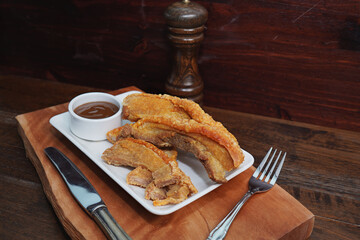Thai food. Crispy fried pork belly cut into pieces on a wooden table.