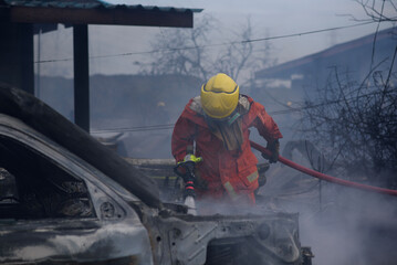 firefighter puts out fire. firefighter in smoke pours burning building with water from hose