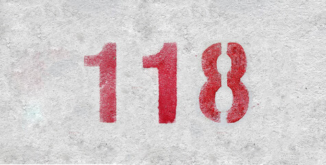 Red Number 118 on the white wall. Spray paint.