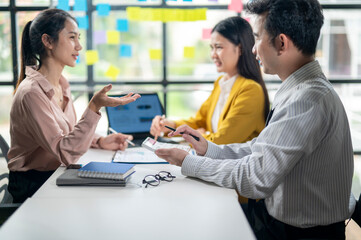 Three people are sitting at a table, discussing something
