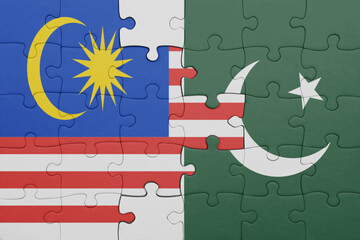 puzzle with the colourful national flag of pakistan and flag of malaysia.