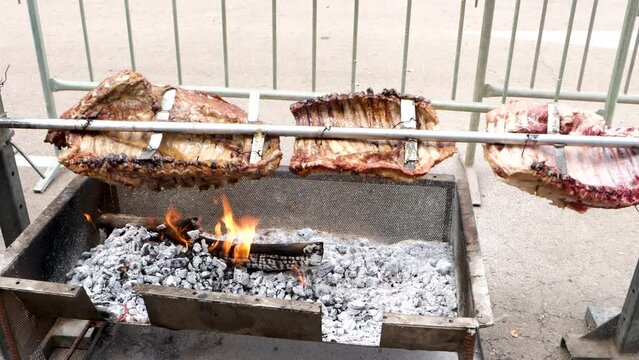 Argentine rib roasting on the grill, beef rib roasted in its salt point, Argentine roast, turning over hot coals