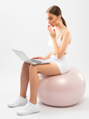 Naklejka premium Slender dark-skinned female blogger in a white tracksuit against a white background. Healthy lifestyle, sports and diet.