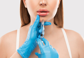 Cosmetologist does injections for lips augmentation and anti wrinkle in the nasolabial folds of a...