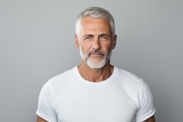 Obraz premium Portrait of a tender man in his 50s sporting a breathable mesh jersey while standing against pastel gray background